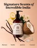 A bottle of Fable & Mane Hydrating Shampoo centered on a warm peach background, surrounded by banana slices, vanilla beans, jasmine flowers, a coconut half, and coconut pieces. Large text at the top reads 'Signature Scents of Incredible India,' and smaller text at the bottom lists the scents: Banana, Vanilla, Jasmine, Coconut.