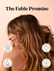 A woman with long, wavy brown hair is shown in profile against a soft peach background, with the text 'The Fable Promise' at the top and four circular icons highlighting product benefits: suitable for all hair types, cruelty free, no silicone, and vegan formula.